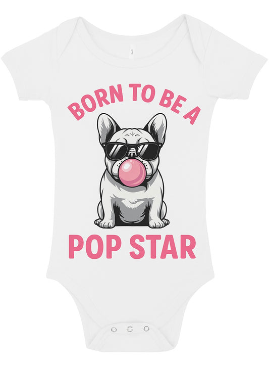 "A white baby bodysuit (onesie) featuring a graphic of a French Bulldog wearing black sunglasses and blowing a large pink bubblegum bubble. Above and below the dog is the text in hot pink: 'BORN TO BE A POP STAR'."