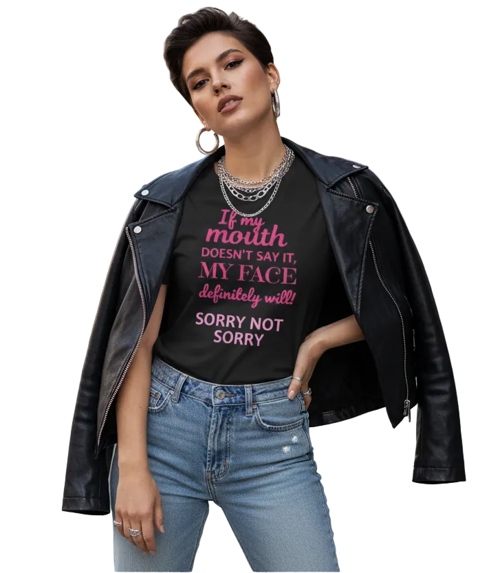 Woman wearing a black leather jacket and blue jeans with a graphic t-shirt on a city street.