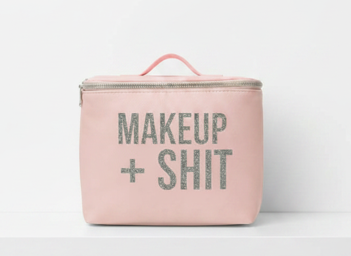 Pink makeup bag with 'MAKEUP + SHIT' text on a white background