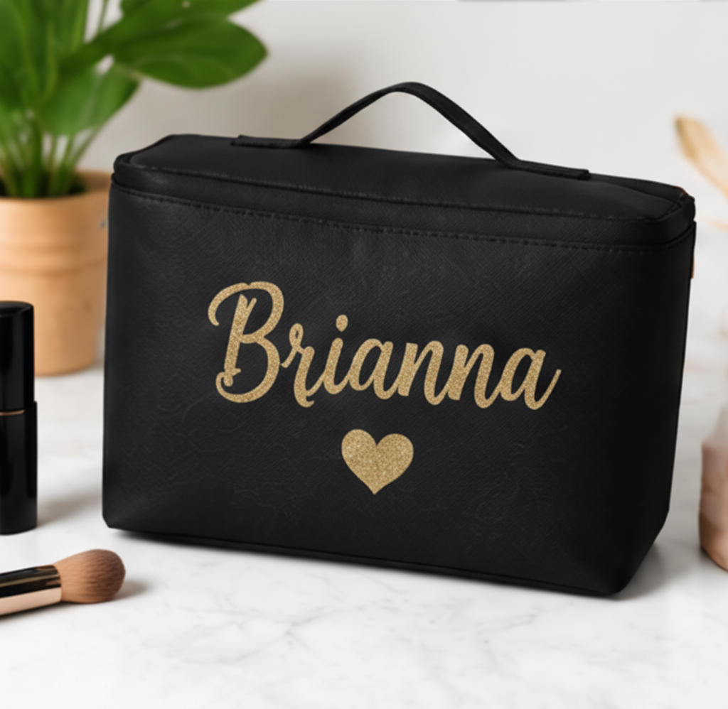 Black cosmetic bag with 'Brianna' and a heart in gold on a light surface.