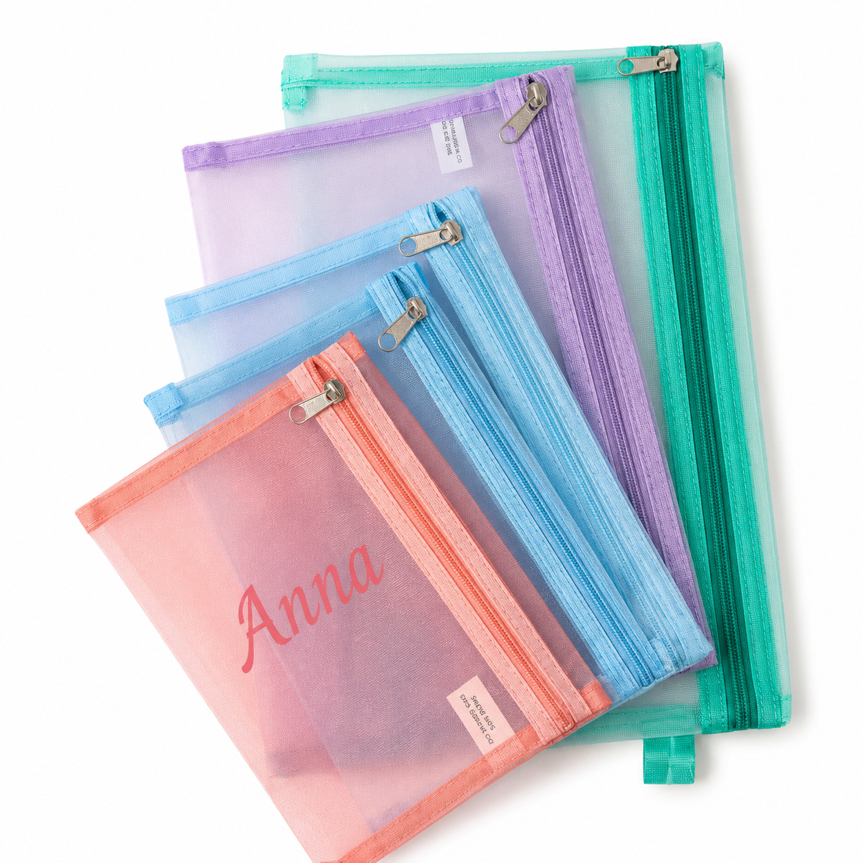 Four translucent mesh zipper pouches in pastel shades of pink, coral, light blue, lavender, and mint green, arranged diagonally on a white background. The front pink pouch is personalized with the name 'Anna' in pink script.