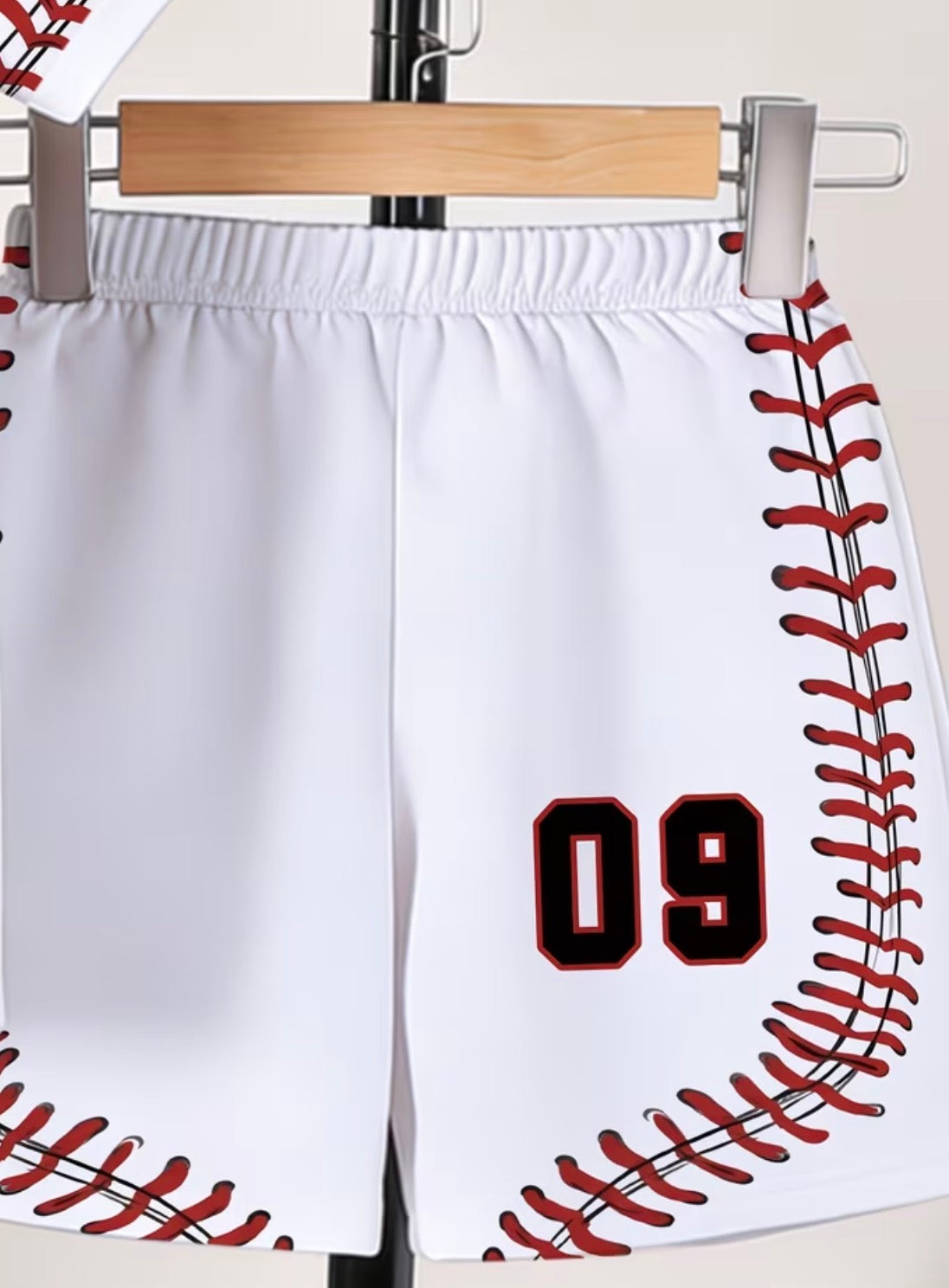 White shorts with red and black baseball-stitching design and number 09 on a hanger.