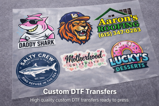 Collection of custom DTF transfers with various designs on a gray background