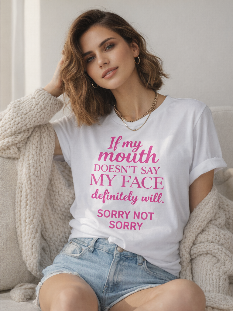 Woman wearing a white t-shirt with pink text sitting on a couch.