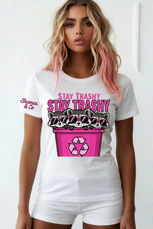 Woman wearing white Stay Trashy raccoon graphic t-shirt by Shamus & Co with hot pink trash can design.